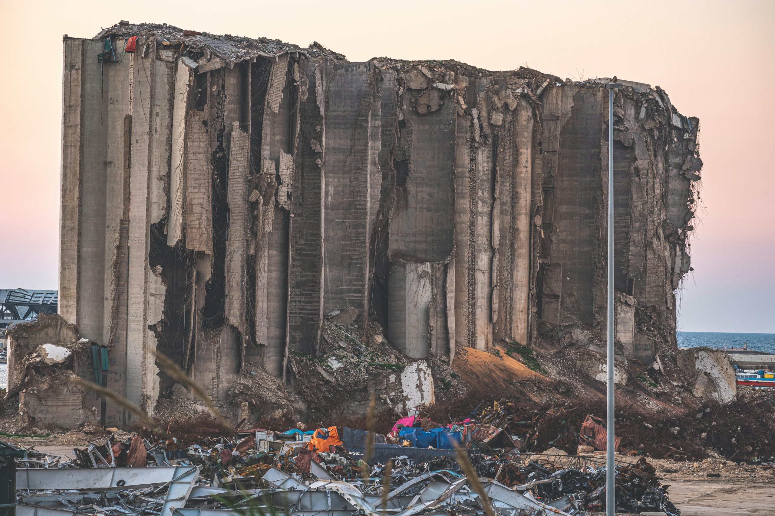 A large concrete structure lies in ruins, symbolizing the destruction in Beirut, Lebanon.
